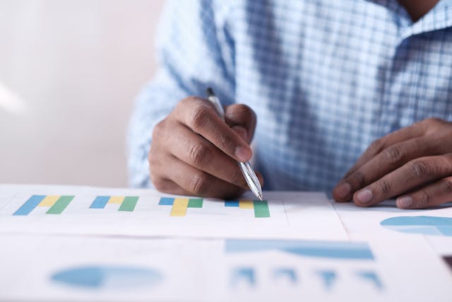 person reviewing various green blue and yellow graphs